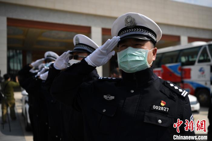 圖為交警們向醫(yī)療隊敬禮?！】灯?攝
