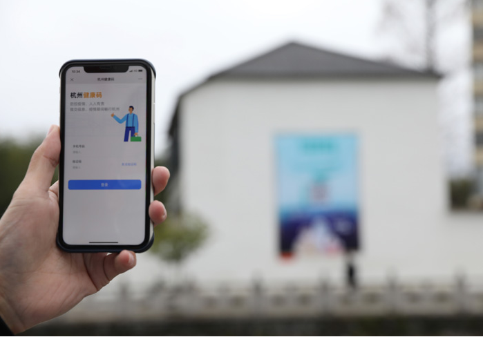 在浙江省杭州市臨安區(qū)天目山鎮(zhèn)，一名居民在“杭州健康碼”海報(bào)上掃碼申領(lǐng)個(gè)人二維碼。新華社發(fā)