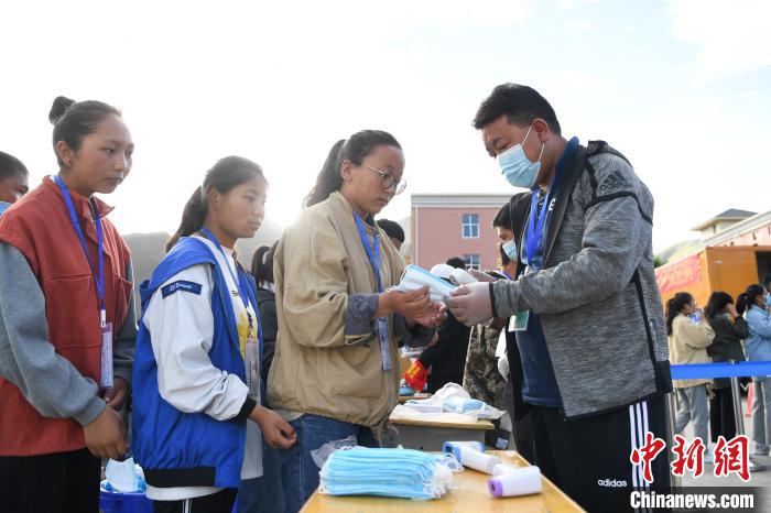 7月7日，考生在拉薩三高考點外領取口罩?！『闻罾?攝